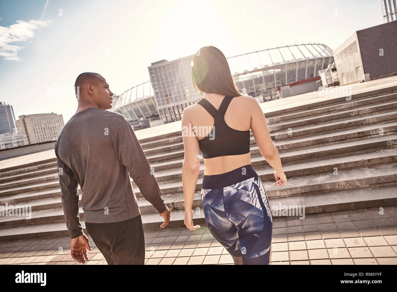 Après l'excellent entraînement. Vue arrière du jeune couple multiracial dans fitness clothes aller à la maison après une formation active ensemble. L'environnement urbain. Couple en bonne santé. Motivation sport concept. Concept de remise en forme. La beauté des femmes. La vie en bonne santé. L'exercice ensemble. Matin active. Loisirs Les Banque D'Images