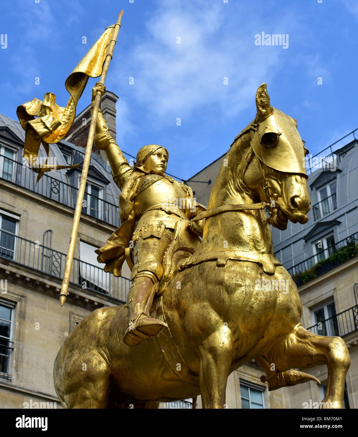 Paris, France. Jeanne d'Arc (Jeanne d'Arc) statue en or. Ciel bleu avec des nuages blancs. Banque D'Images