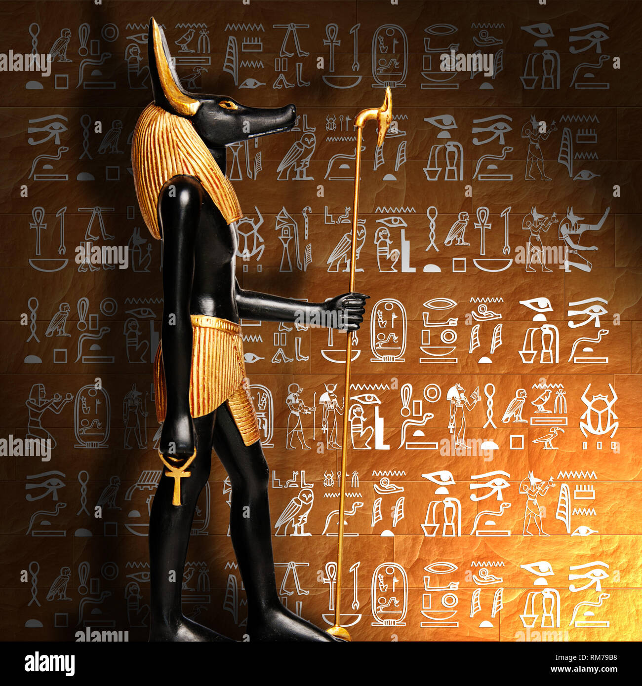 Dieu égyptien Anubis en face d'un mur d'hiéroglyphes Banque D'Images