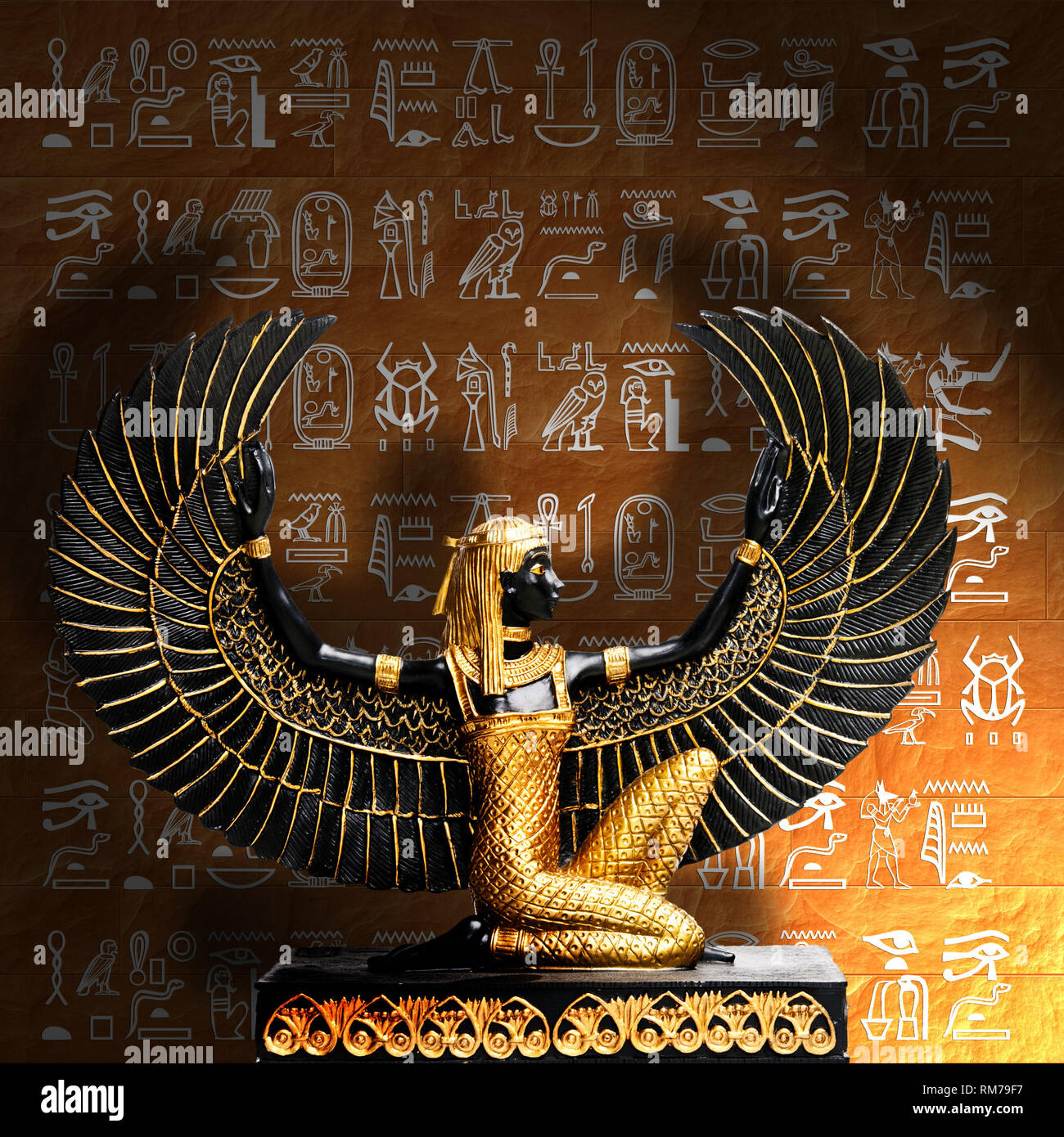 Statue de Maat déesse égyptienne Isis ou devant un mur de hiéroglyphes Banque D'Images