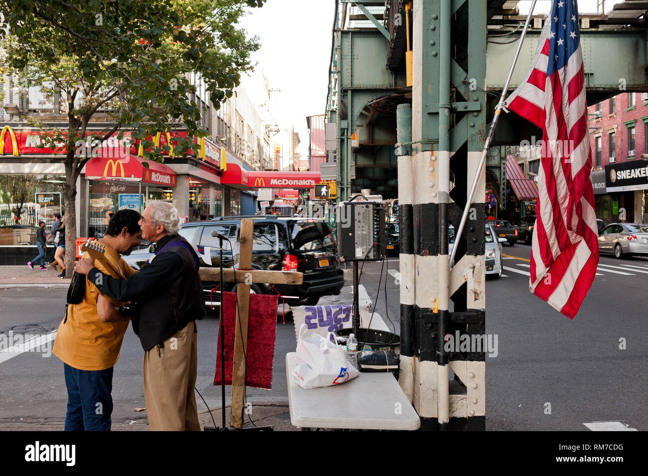 Artiste de rue ami accueille sur coin de rue à Brooklyn New York, avec le drapeau américain accroché sur perche Banque D'Images