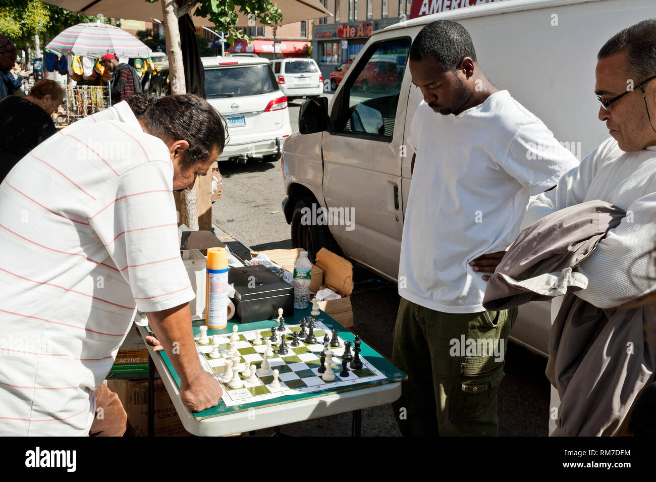 Mixed Race hommes jouent un jeu d'échecs à l'extérieur, au soleil sur la terrasse du domaine de Harlem New York USA Banque D'Images
