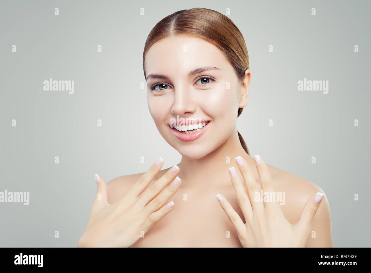 Femme excité avec une peau saine, sourire mignon et french manucure main. Concept de l'offre de cosmétologie Banque D'Images
