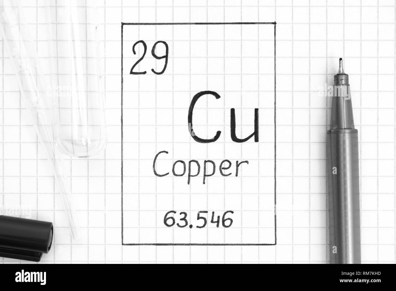 Le tableau périodique des éléments. Élément chimique Cu Cuivre de l'écriture avec un stylo noir, tube à essai et pipette. Close-up. Banque D'Images