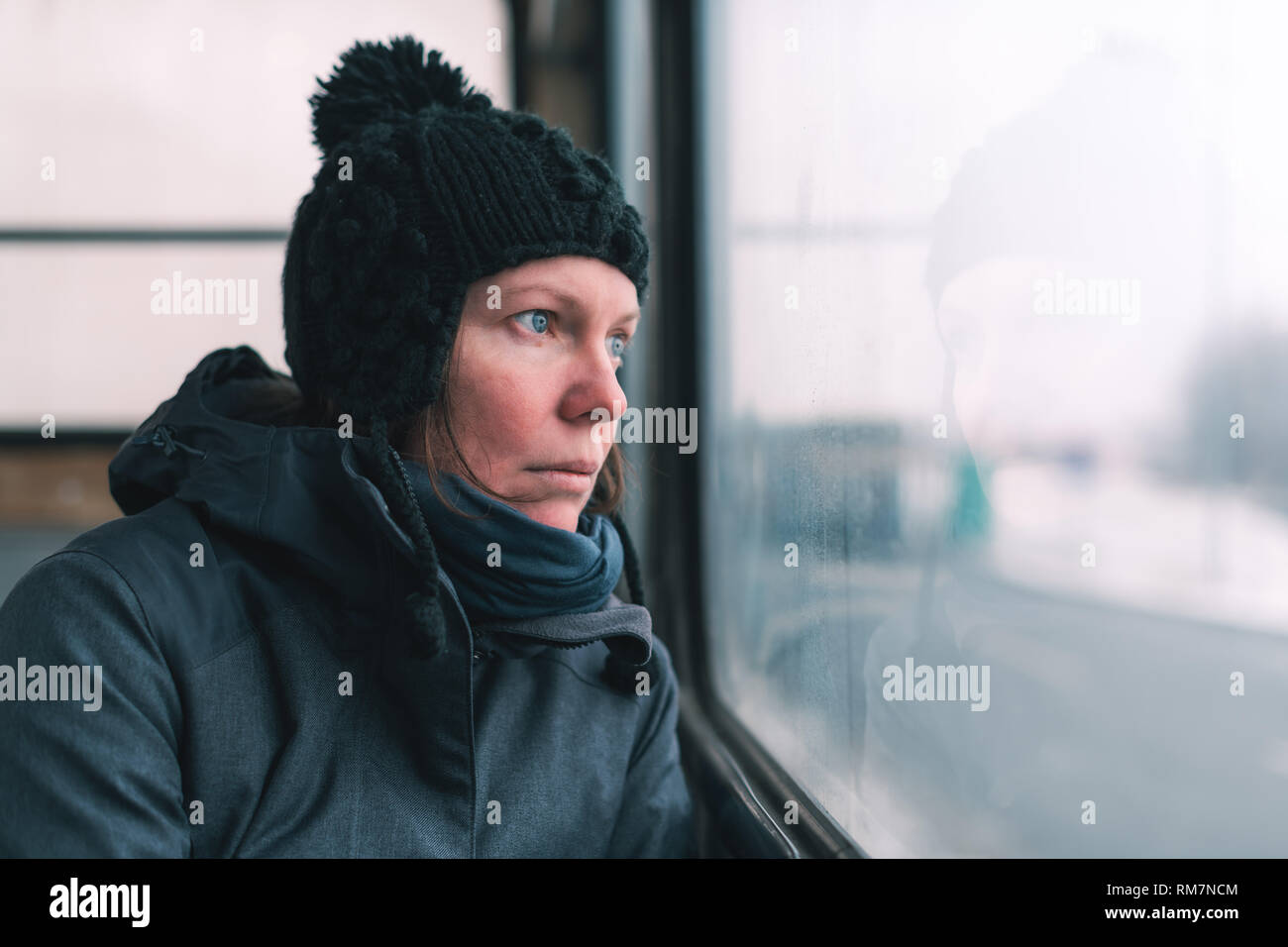 Femme triste sur le bus à la recherche d'une fenêtre à la rue sur froide journée d'hiver Banque D'Images