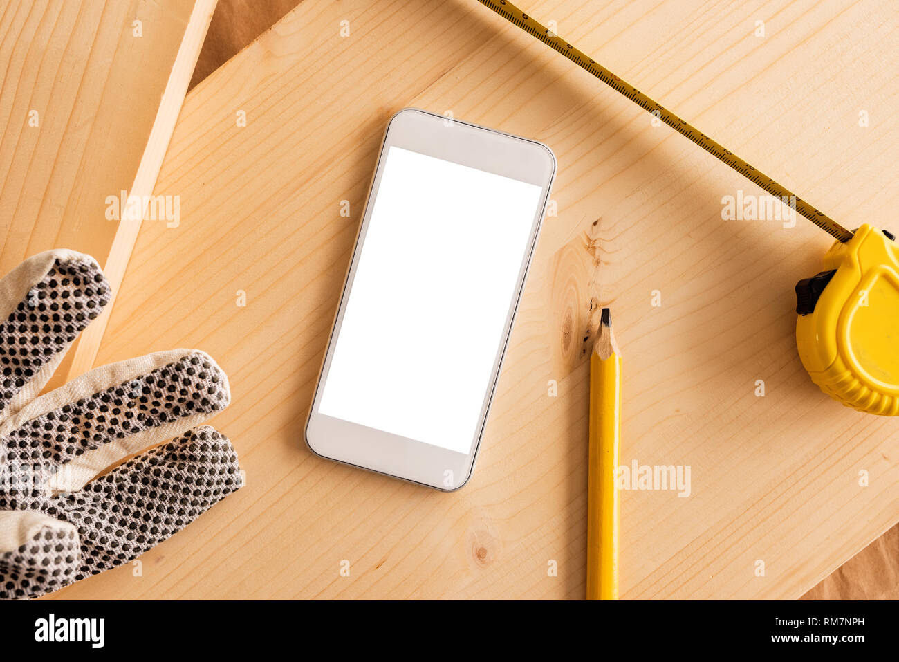 Smartphone moderne blanc avec écran vide maquette dans la petite entreprise de menuiserie atelier de menuiserie, vue du dessus Banque D'Images