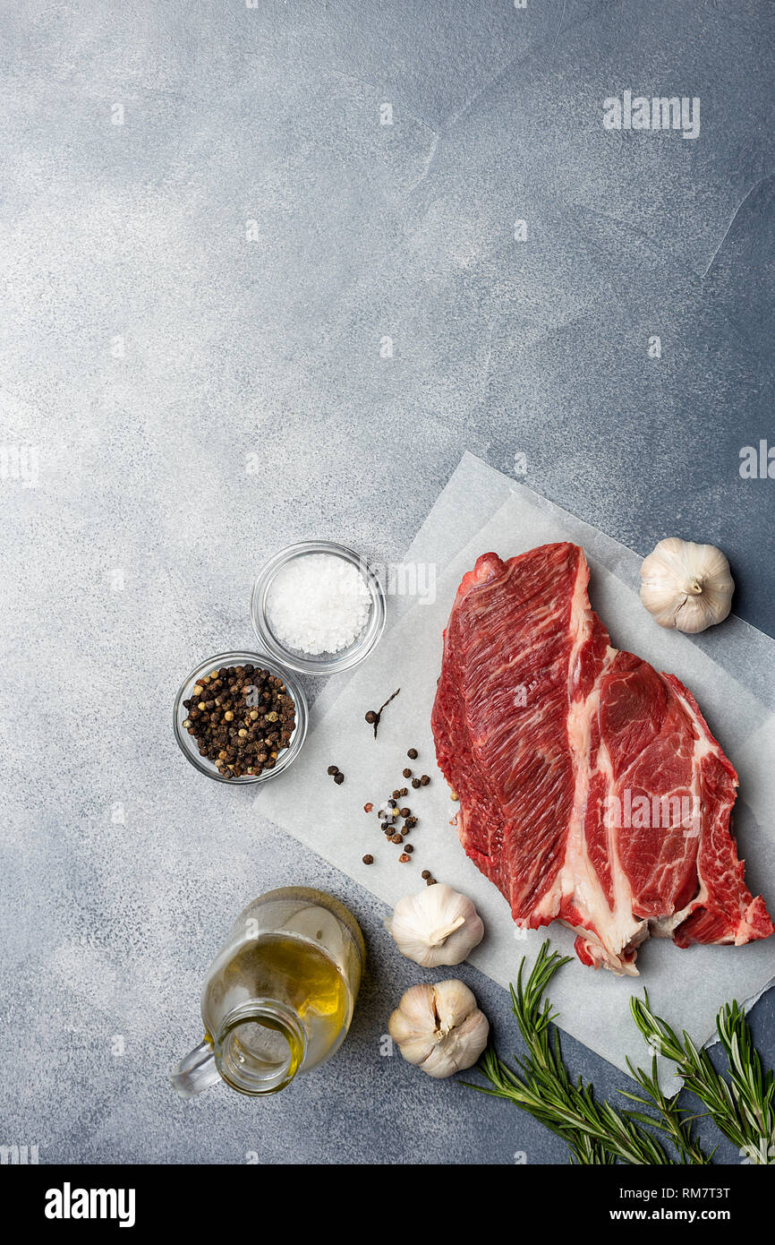 La viande fraîche de boeuf savoureux avec des épices comme l'ail, sel, poivre, herbes à craft sur fond gris. Concept de la nourriture allemande Banque D'Images La viande fraîche de boeuf savoureux avec des épices comme l'ail, sel, poivre, herbes à craft sur fond gris. Concept de la nourriture allemande Banque D'Images