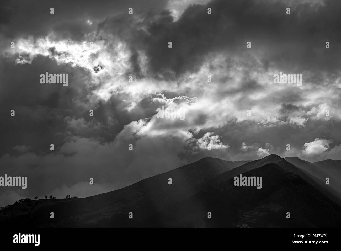 Le majestueux volcan Pichincha active dans la ville de Quito au coucher du soleil en noir et blanc avec une sunbeam, magique des Andes, en Équateur. Banque D'Images