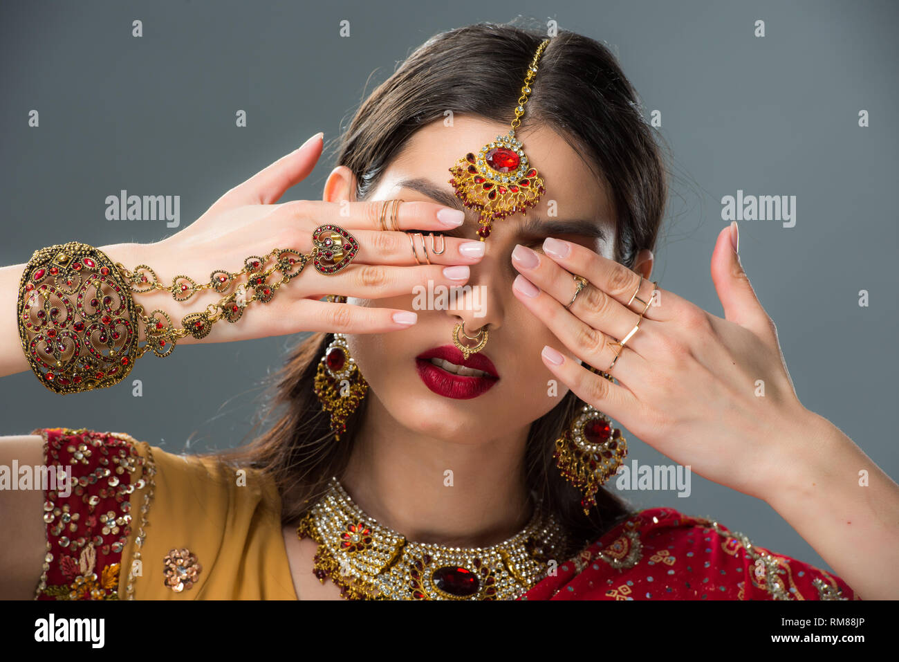 Belle femme indienne avec bindi fermer les yeux, isolé sur gris Banque D'Images