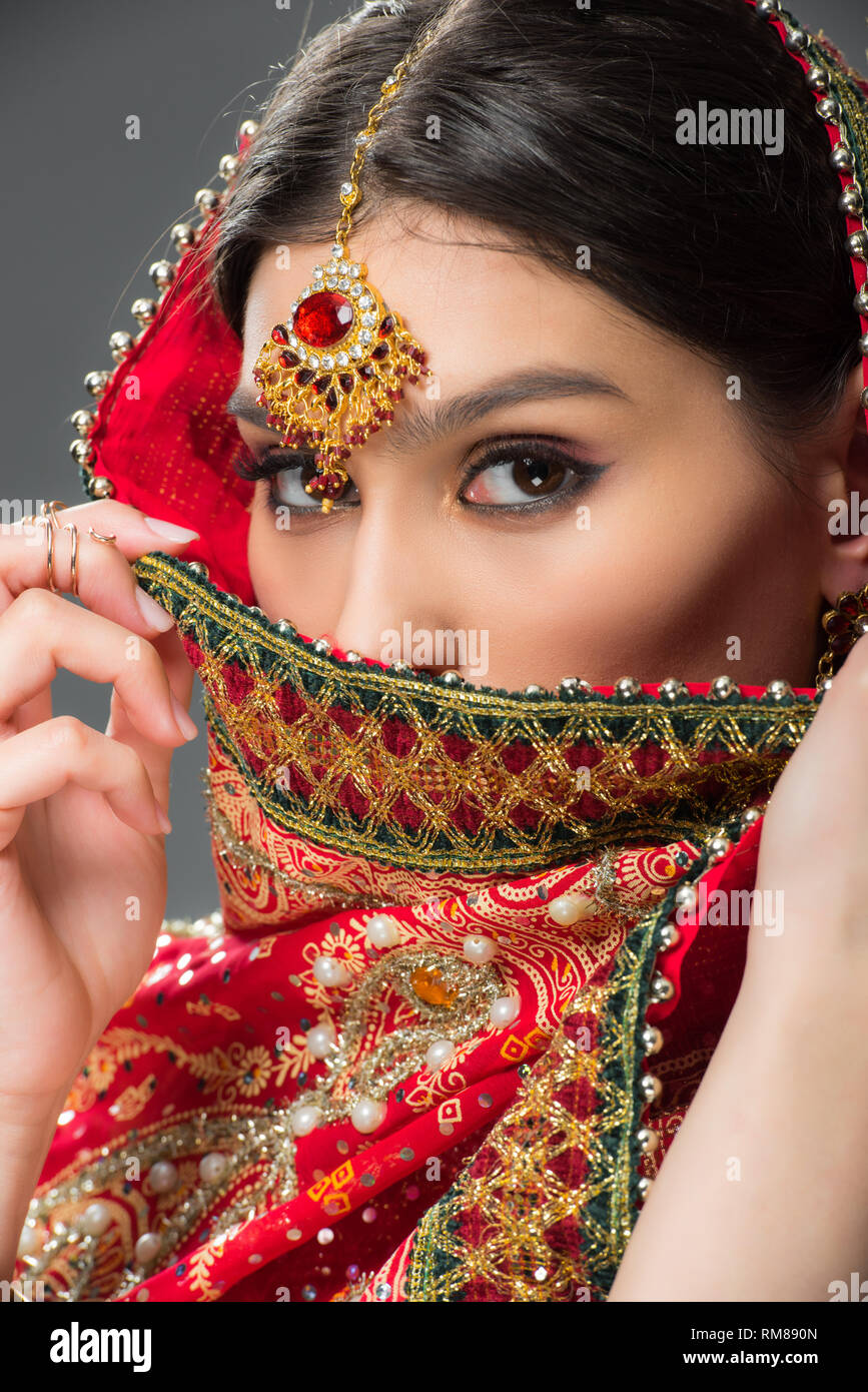 Belle femme indienne en sari traditionnel et bindi, isolé sur gris Banque D'Images