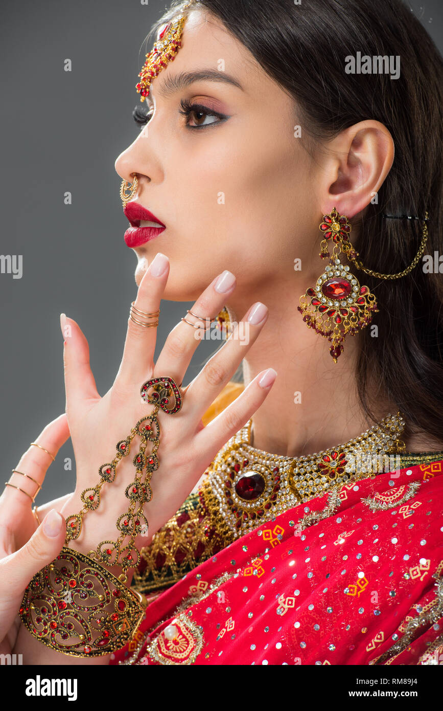 Beautiful indian woman gesturing dans accessoires, isolé sur gris Banque D'Images