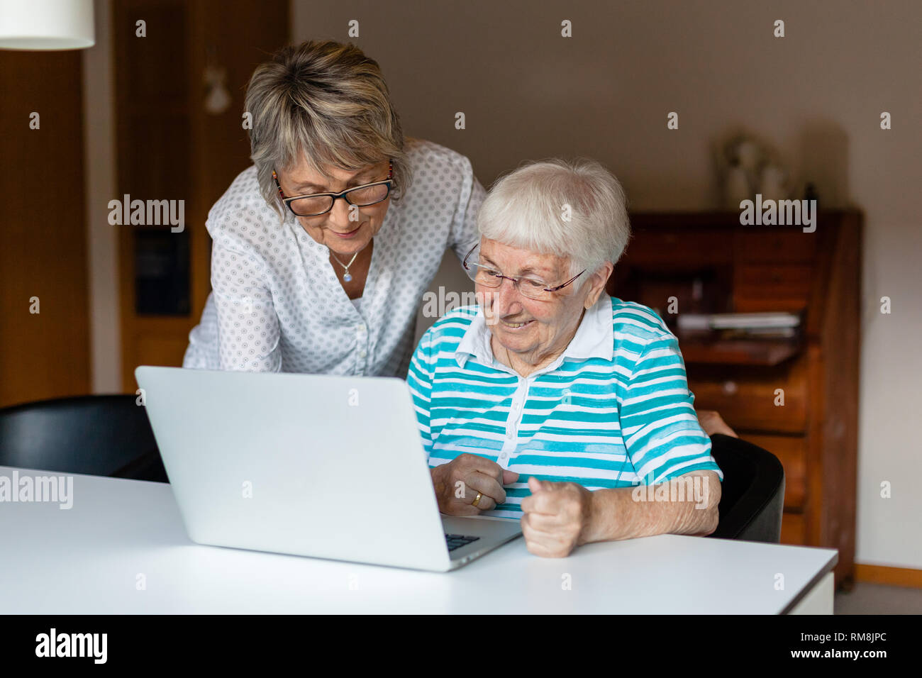 Plus de 90 ans senior lady en utilisant un ordinateur portable avec l'aide de sa fille Banque D'Images