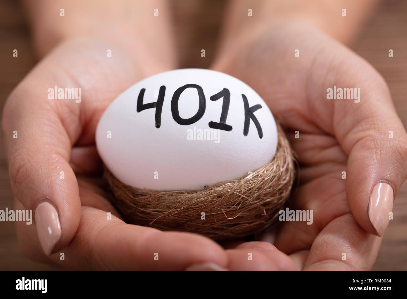 Close-up of Human Hands Holding 401k White Egg in Nest Banque D'Images