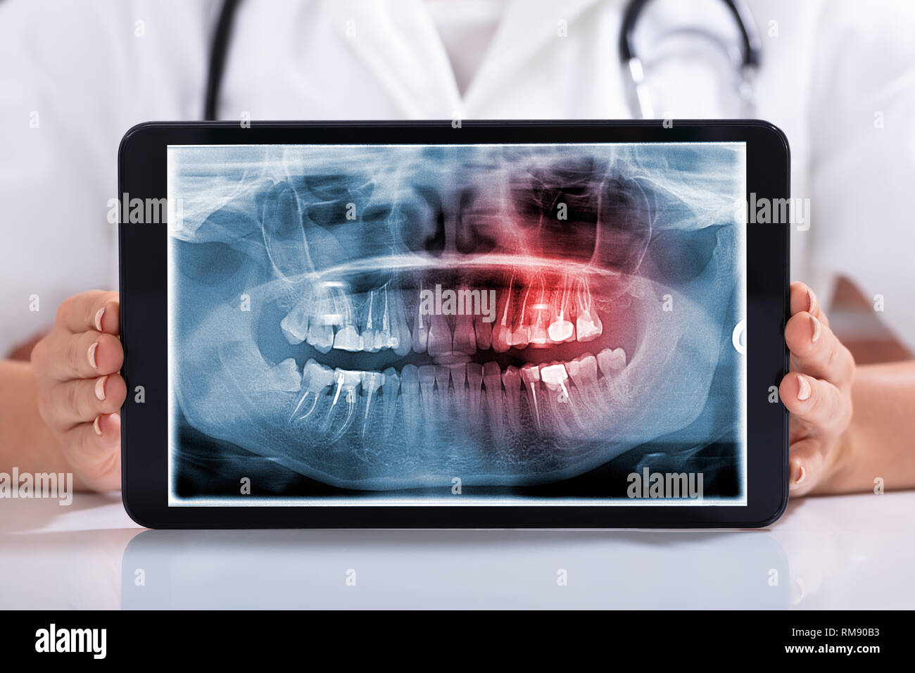 Mid Section of Female Doctor's main montrant écran blanc ordinateur portable sur 24 Banque D'Images