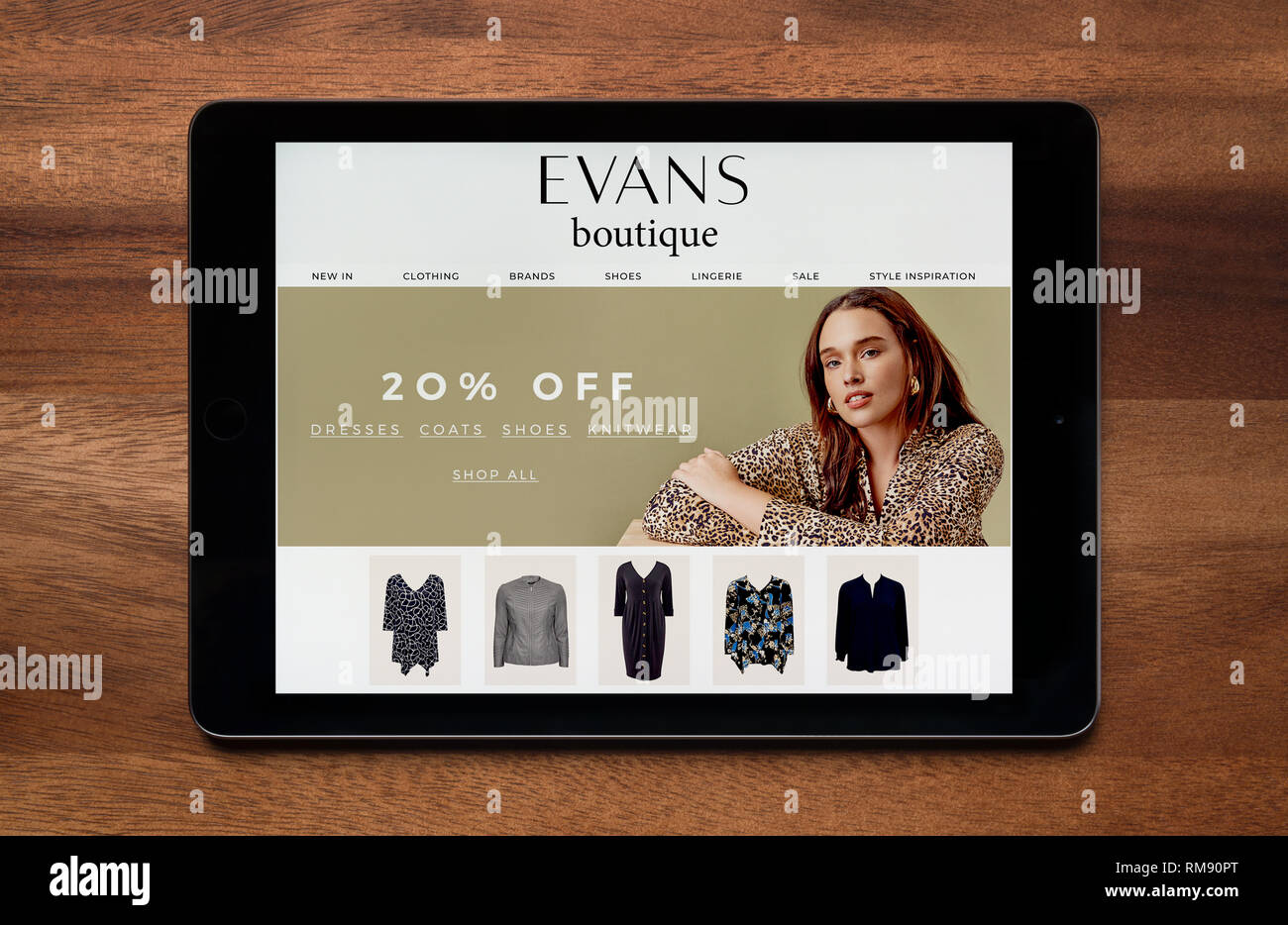 Le site web de Boutique Evans est vu sur un iPad tablet, qui repose sur une table en bois (usage éditorial uniquement). Banque D'Images
