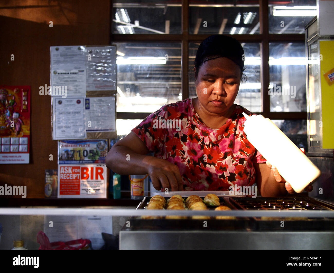 ANTIPOLO CITY, PHILIPPINES - 8 février 2019 : les vendeurs d'aliments cuisiner et vendre sur son Takoyaki assortis food. Banque D'Images