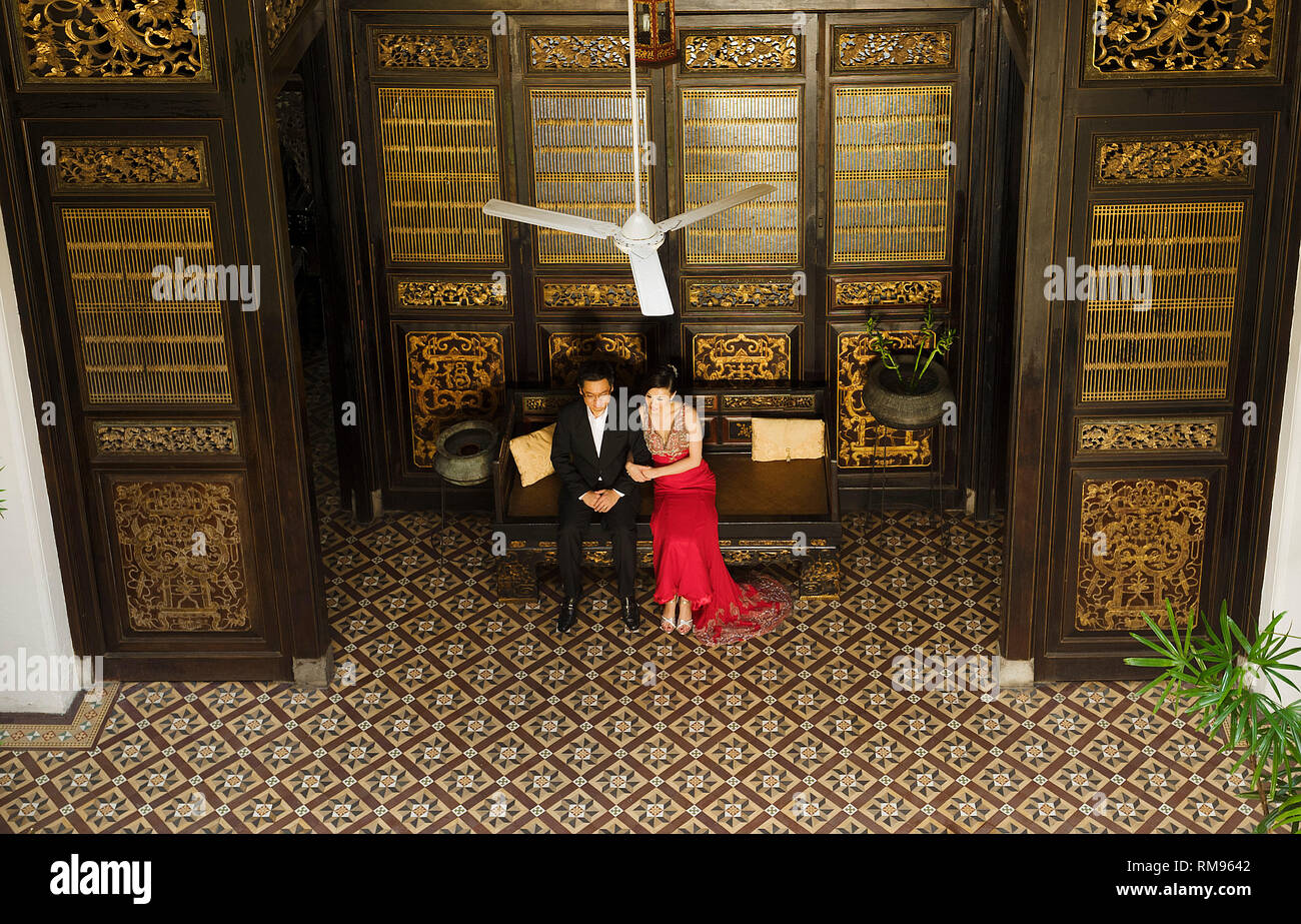 Couple leurs photos de mariage en face de séparation sculpté porte dans la Cheong Fatt Tze Mansion, le bleu à George Town, Penang, Malaisie Banque D'Images