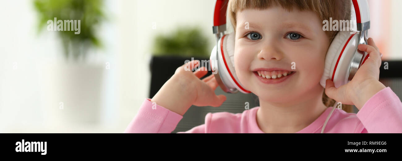 L'enfant assis au casque satisfait Banque D'Images