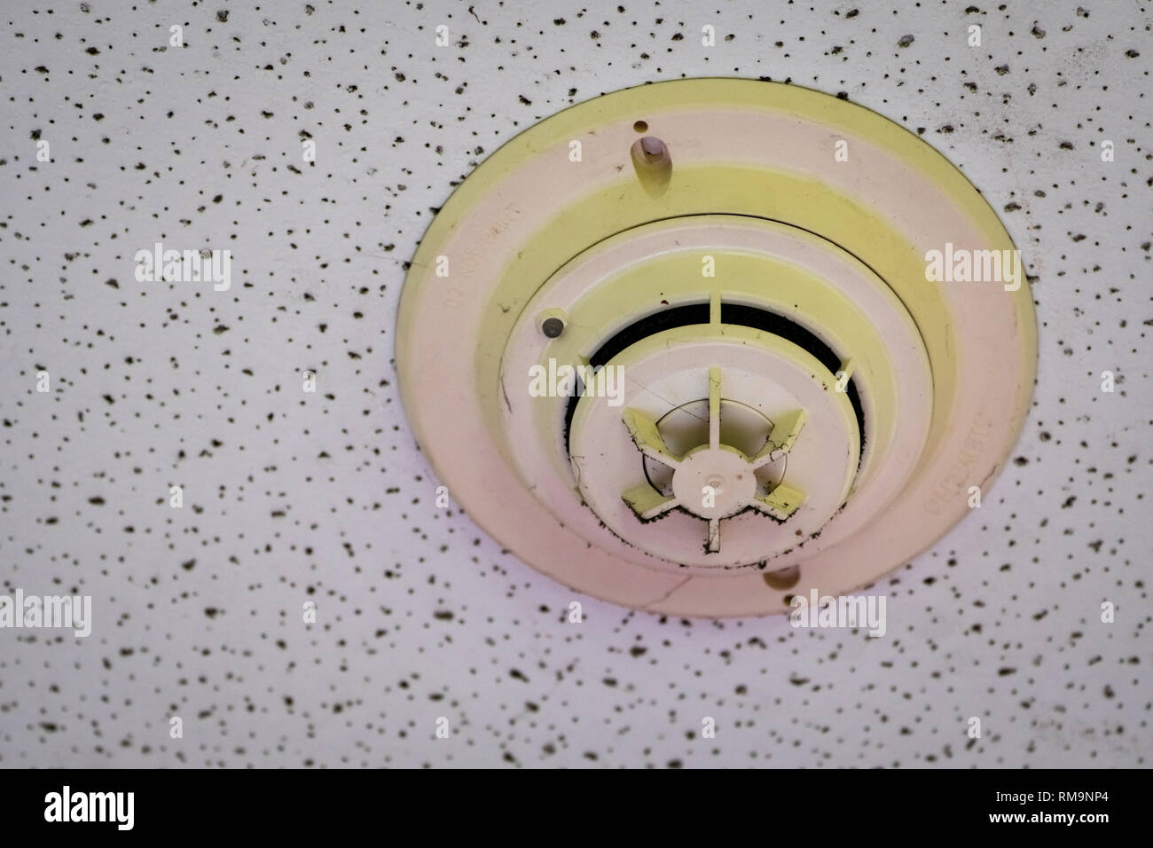 Vieux et sale avec détecteur de fumée d'araignée au Plafond mur. Le système d'alarme incendie dans la chambre ne fonctionne pas. L'équipement d'urgence en vacances besoin de nettoyer et Banque D'Images
