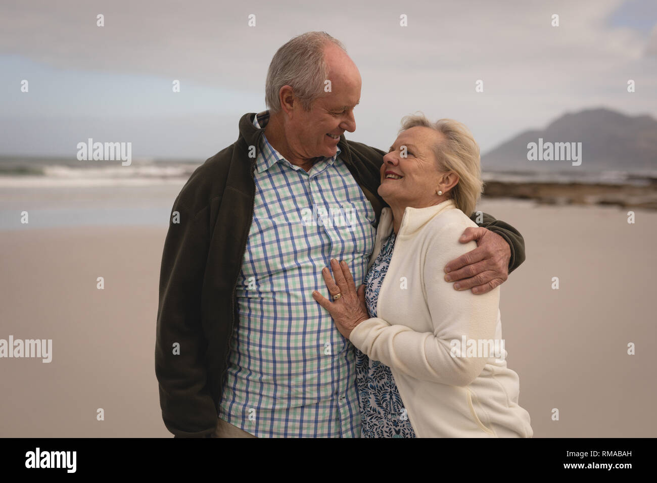 Senior couple enlacés sur la plage Banque D'Images
