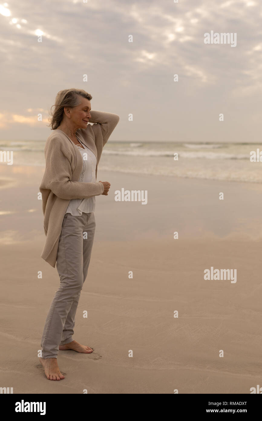 Senior woman standing avec les yeux fermés sur la plage Banque D'Images