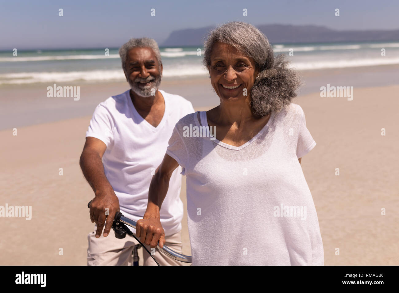 Man avec location et looking at camera on beach Banque D'Images