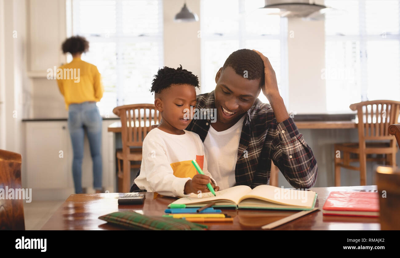 African American father aider son fils à faire ses devoirs à la table Banque D'Images
