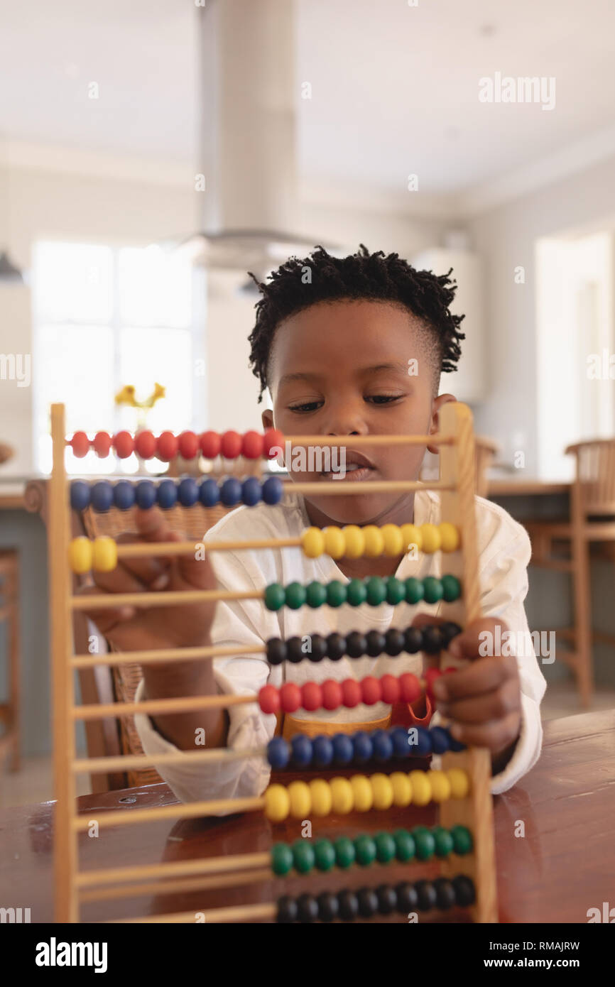African American boy l'apprentissage des mathématiques avec abacus à table Banque D'Images
