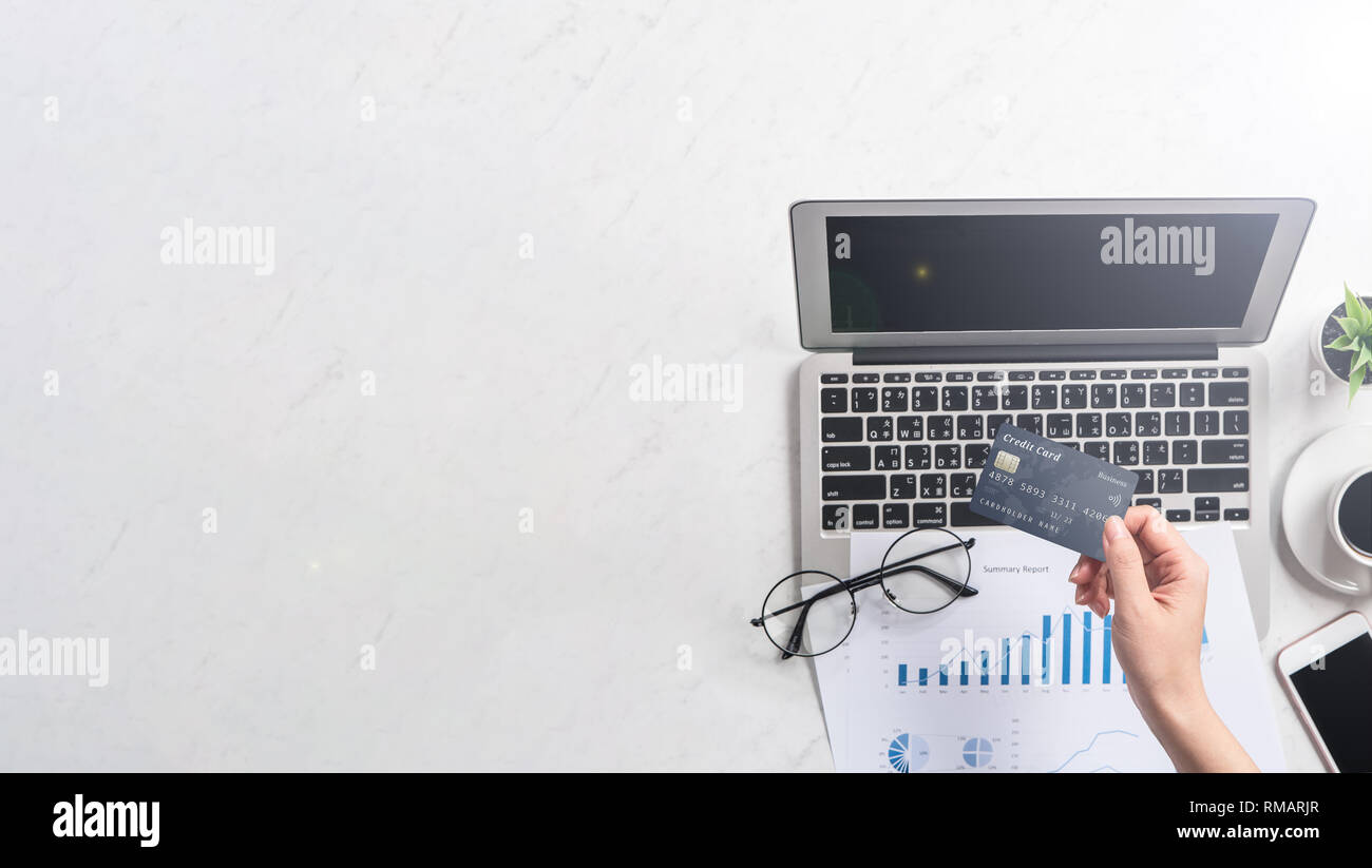 Concept d'une femme est en train de faire un achat en ligne, carte des maquettes et téléphone portable sur office bureau isolé sur fond en mode copie, l'espace, Banque D'Images