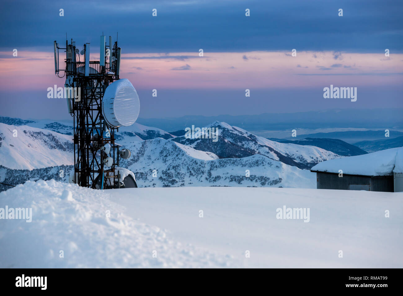 Tour de communication avec les antennes et paraboles à l'arrière-plan d'un paysage de montagne en hiver, au coucher du soleil. Gudauri, Géorgie Banque D'Images