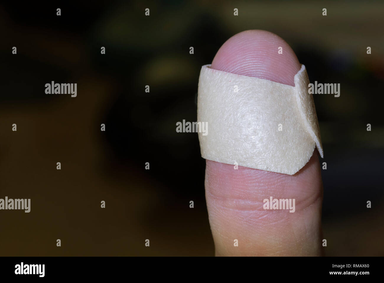 Son doigt avec un emplâtre (aide de bande) autour de lui après une blessure mineure. Banque D'Images