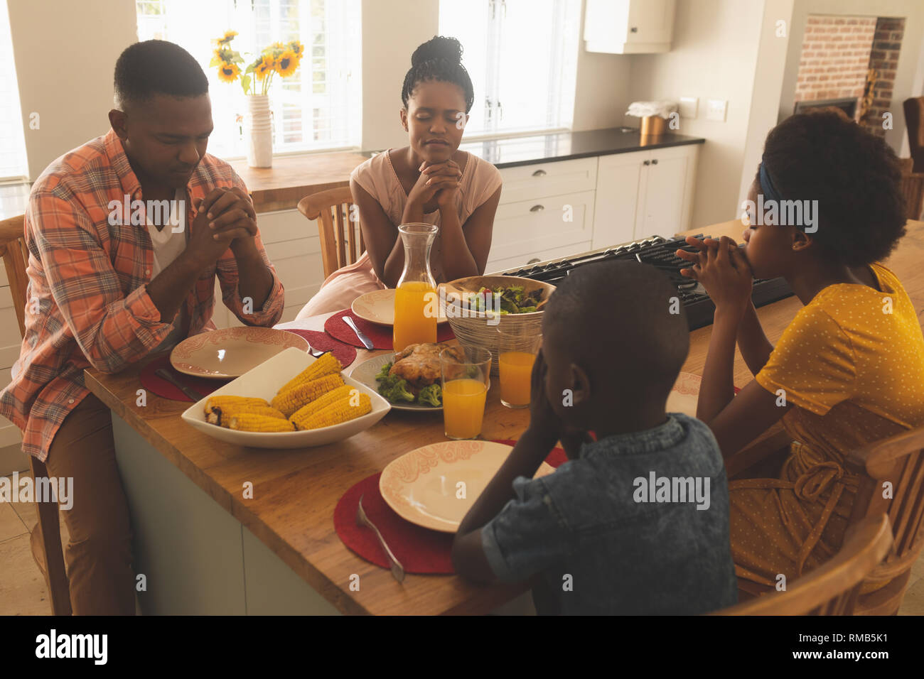 African American family priant ensemble à table à manger Banque D'Images
