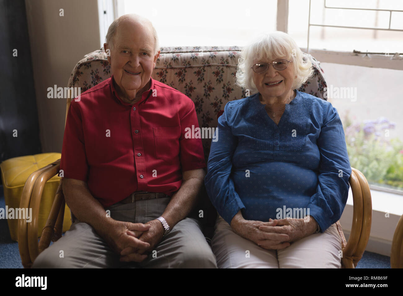 Vue avant du couple part clasped looking at camera in nursing home Banque D'Images