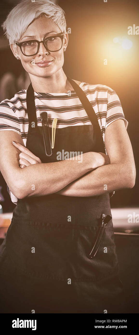 Coiffure Femme debout avec bras croisés au salon Banque D'Images