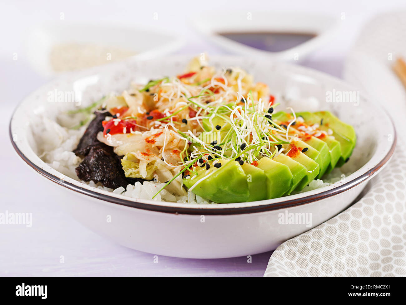 Salade végétalienne avec riz, chou kimchi mariné, avocat, sésame et nori sur la cuvette. Sushi-alimentaire tendance hybrides. Frais généraux Banque D'Images