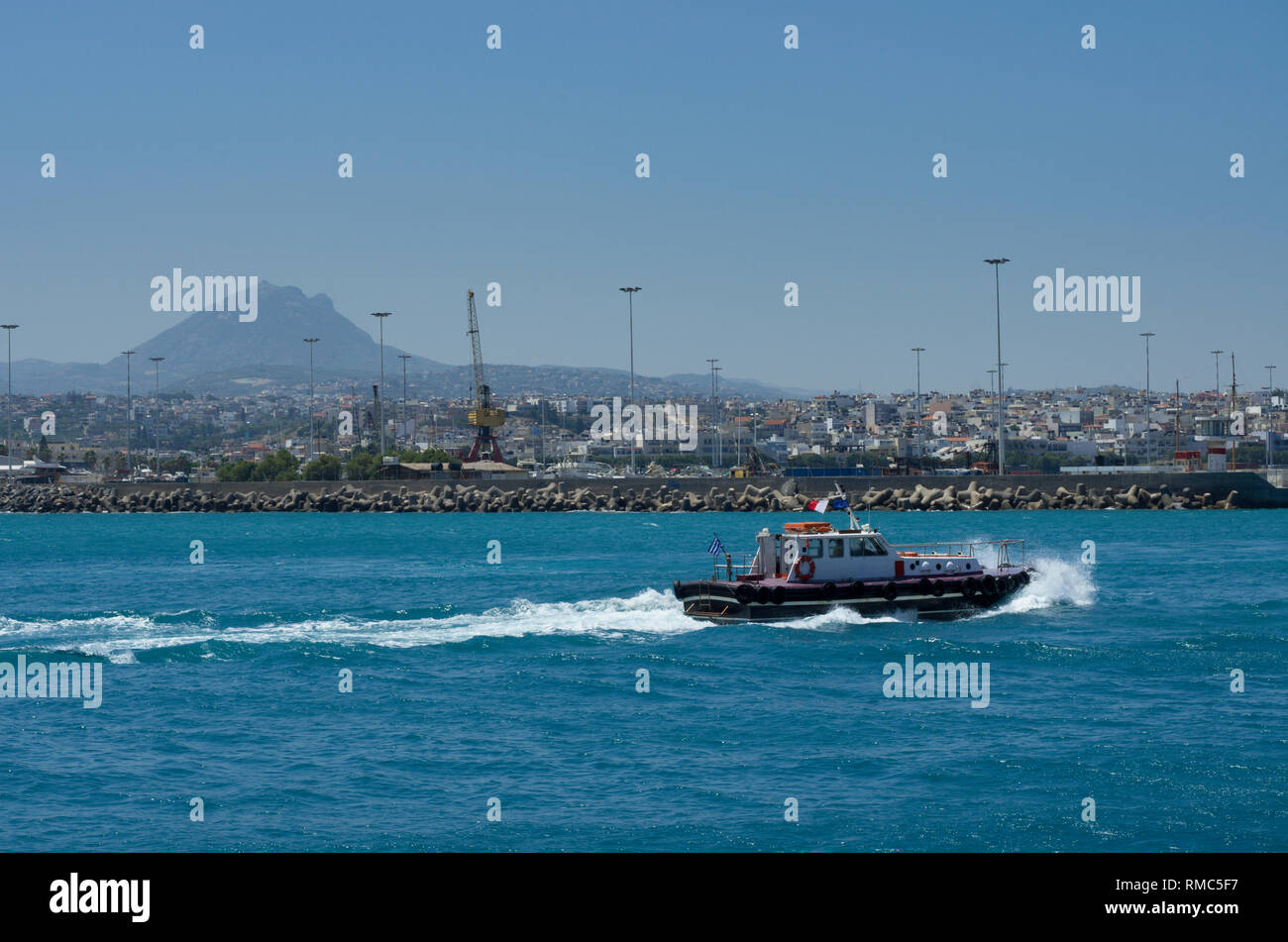 Bateau pilote la voile sur la mer d'Azur dans le port d'Héraklion, sur l'arrière-plan de la montagne et de la ville (Grèce) Banque D'Images