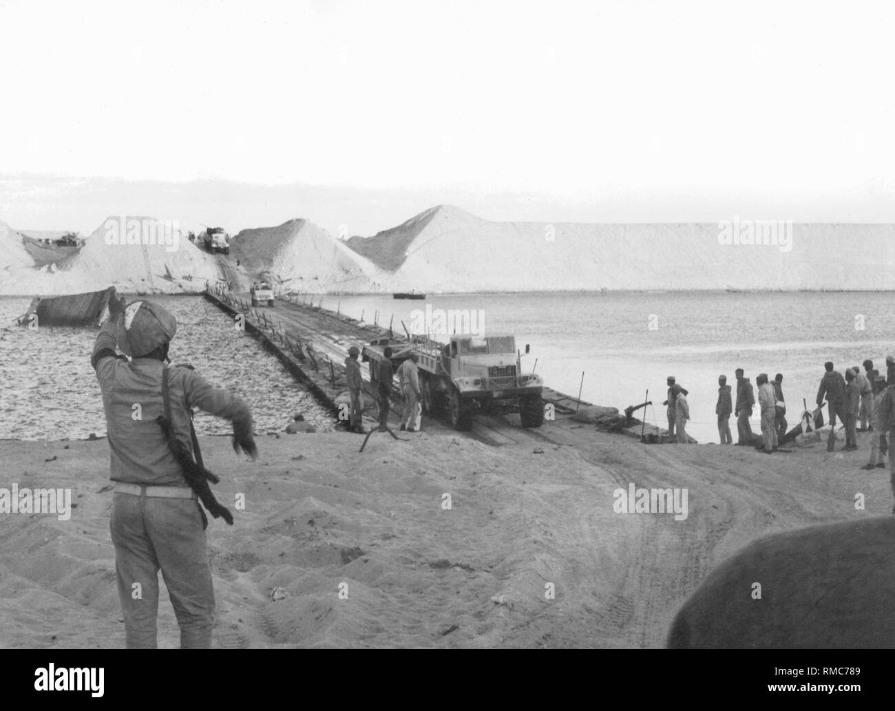 Un Égyptien pont de bateaux sur le Canal de Suez vu depuis le côté égyptien. Sur la rive opposée sont les entailles profondes que les egyptiens rincée avec des canons à eau dans le mur israélien, pour permettre le passage de leurs troupes et la construction des ponts. Banque D'Images