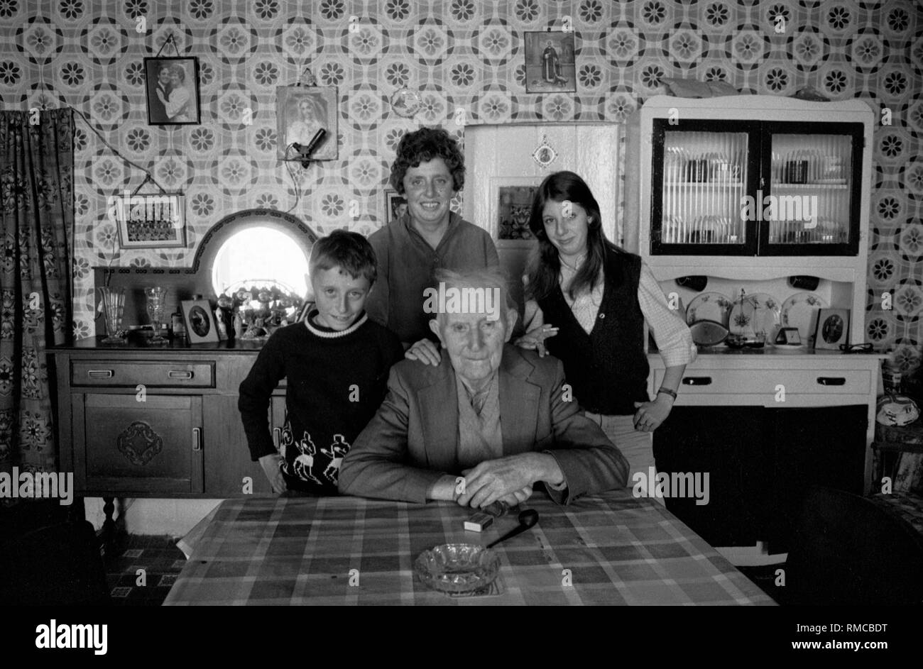 Années 1970 Portrait de famille irlandais de trois générations à l'intérieur de la maison familiale.Limerick, dans le comté de Limerick Eire.Côte ouest de l'Irlande du Sud 70 famille Storan, Brennans Row Limerick.Joe a 80 ans et a vécu ici dans ce cottage de deux pièces tout est la vie, il n'y a pas d'eau chaude HOMER SYKES Banque D'Images