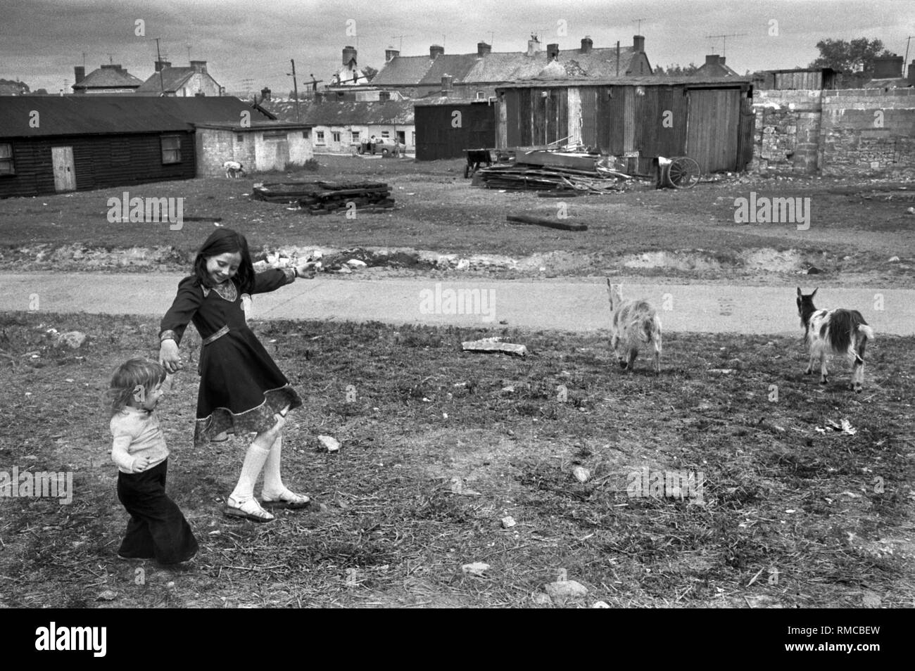 Adolescente irlandaise des années 1970 avec sœur jouant à l'extérieur de Limerick, dans le comté de Limerick, Eire. Chèvres bétail laissé à errer, ils ne sont pas écrus. Côte ouest de l'Irlande du Sud des années 70 HOMER SYKES Banque D'Images