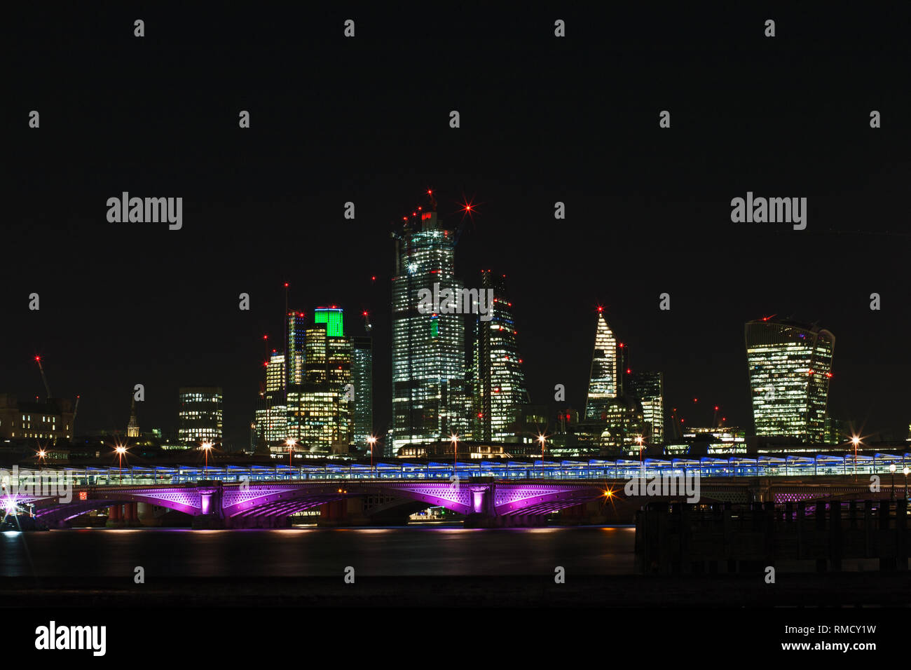 Le quartier financier de Londres avec des gratte-ciel illuminés la nuit Banque D'Images