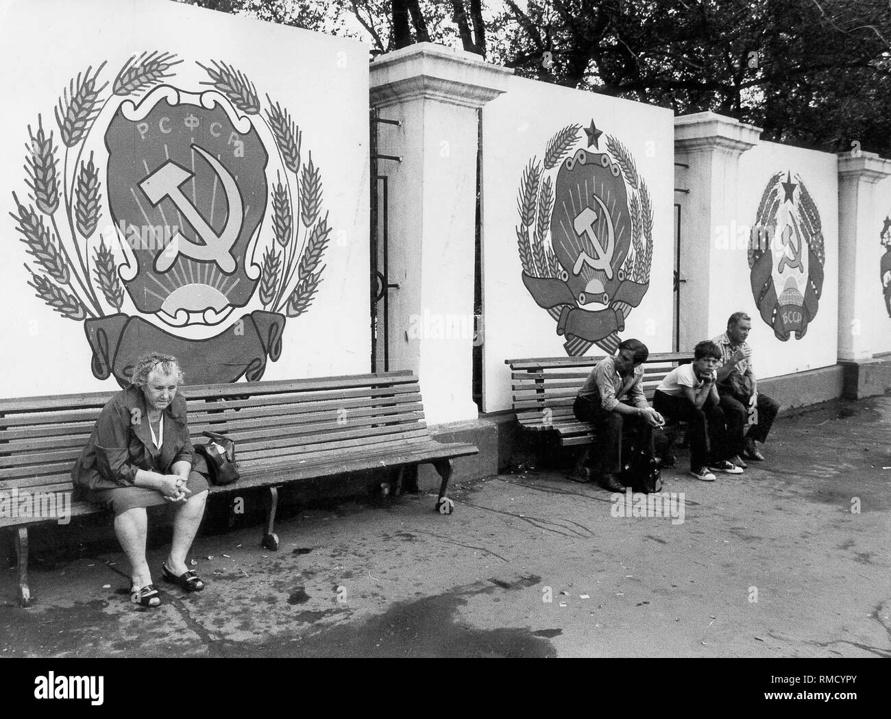 Les résidents sont assis dans un square à Novossibirsk, dans le contexte de la propagande soviétique. Banque D'Images