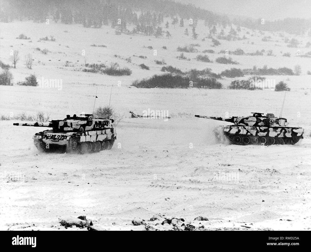 Deux chars Leopard 2 de route à travers un paysage hivernal. Banque D'Images