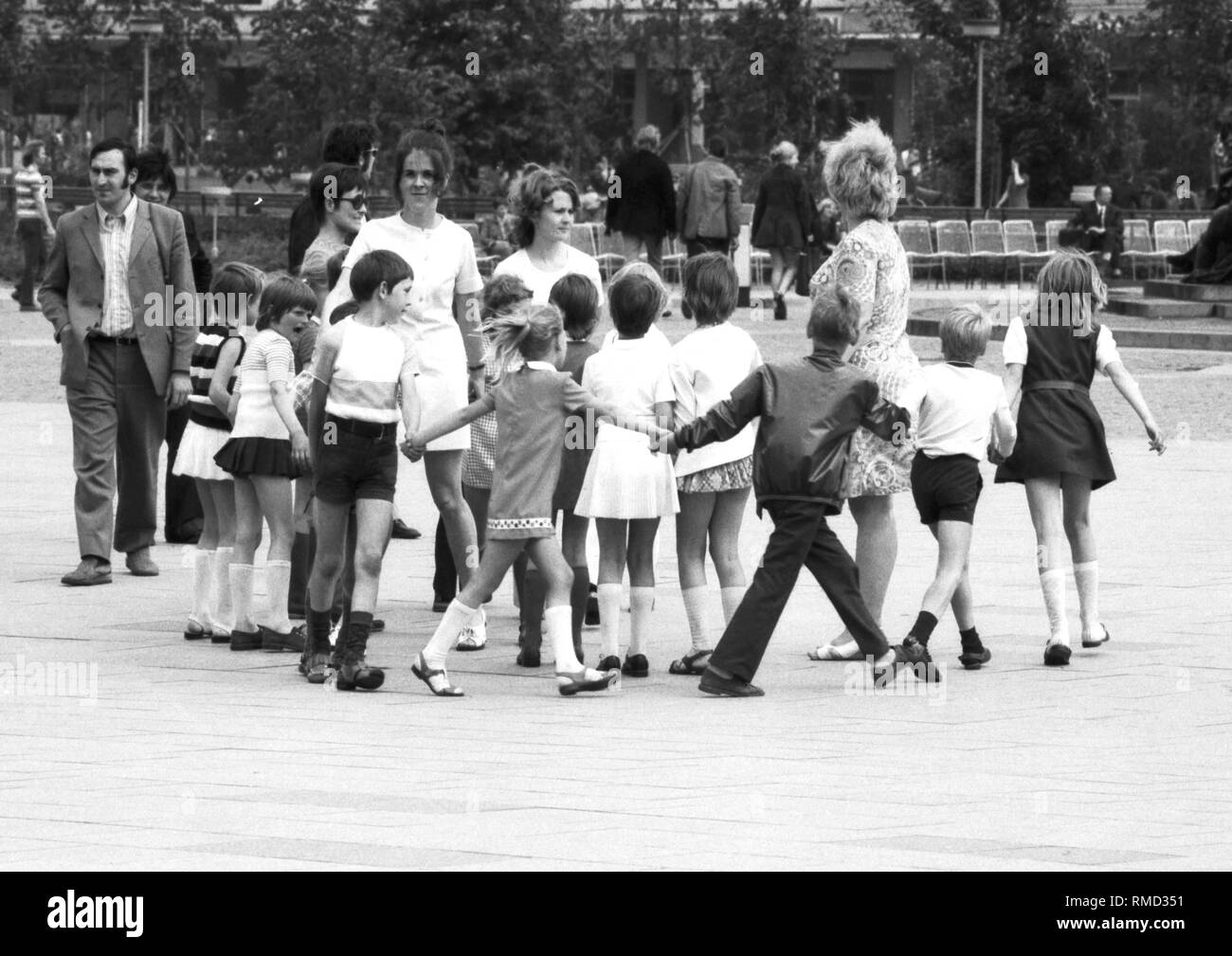 Groupe de la maternelle à la Neptunbrunnen derrière la Fernsehturm sur l'Alexanderplatz à Berlin Est. Banque D'Images