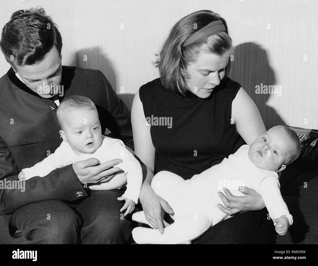 Père et mère avec deux bébés, probablement des jumeaux. Banque D'Images