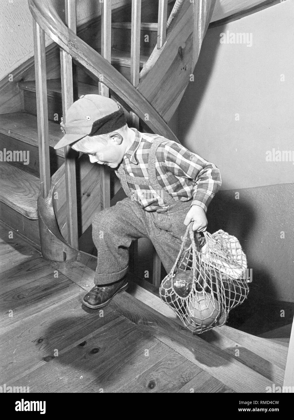Un enfant porte achat grâce à un escalier. Banque D'Images