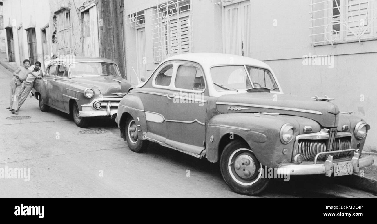 Scène de rue à Santiano de Cuba. Une Ford Business Coupe (construit en 1946) et une Chevrolet Bel Air (construit en 1953) parc sur le bord de la route. Banque D'Images