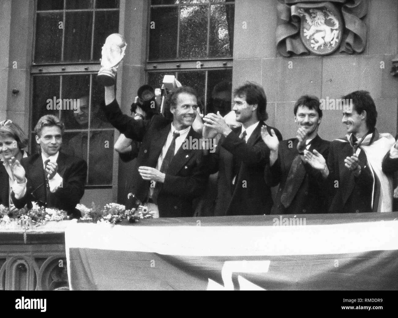Joueurs allemands après la victoire à Rome à Francfort. Avec le trophée, Franz Beckenbauer, sur la gauche, Thomas Haessler, gauche de Beckenbauer, Raimond Aumann, extrême droite, Pierre Littbarski. Banque D'Images
