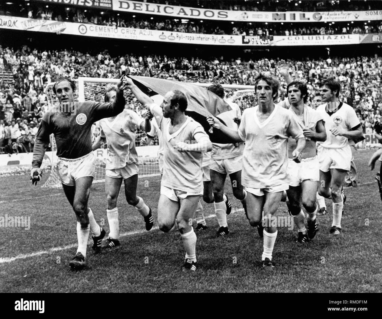 Après la victoire 1-0 sur l'Uruguay dans le match pour la troisième place, l'équipe nationale allemande est en marche un tour d'honneur dans le stade avec le drapeau de l'Allemagne, dirigé par le gardien Horst Wolter, Uwe et Virginia Afflerbach Hannes Loehr. Banque D'Images