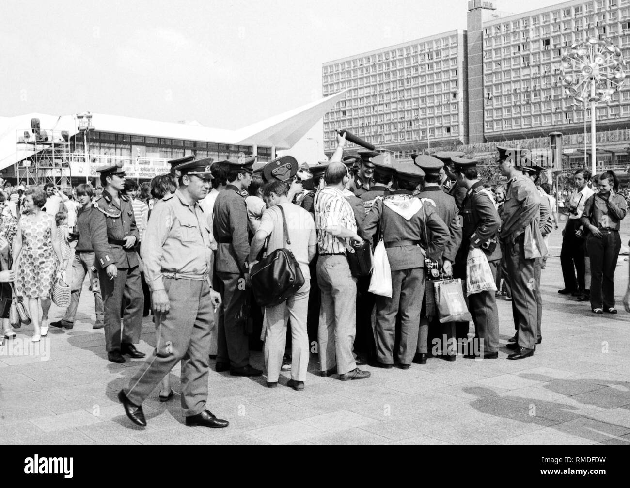Le Festival mondial de la jeunesse et des étudiants entre le 28 juillet - 5 août, 1973 à Berlin Est : les jeunes et les soldats de l'armée du peuple est-allemand en uniforme sur Alexanderplatz lors d'une interview à la télévision. Banque D'Images