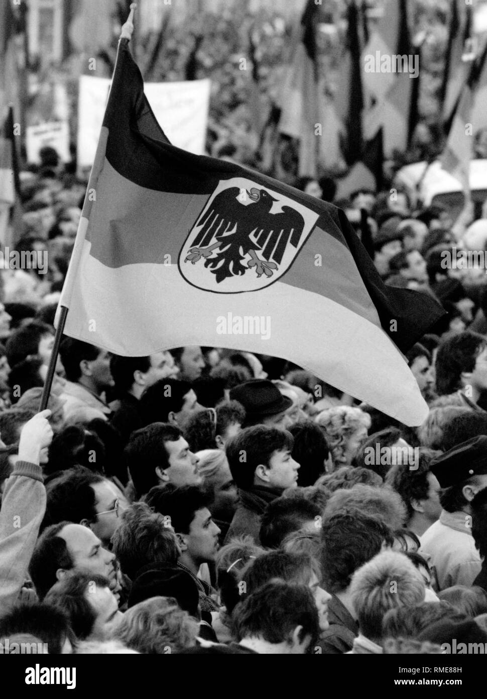 Personnes agitant avec drapeaux allemands lors d'une réunion électorale à l'occasion des élections législatives de la RDA. Banque D'Images